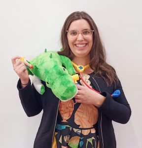 A photo of Emma playing doctor to a plush alligator!